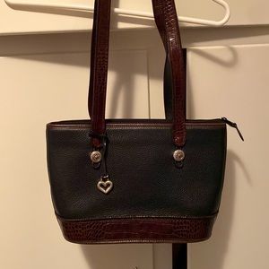 This is a numbered black leather shoulder bag with chic. Brown trim